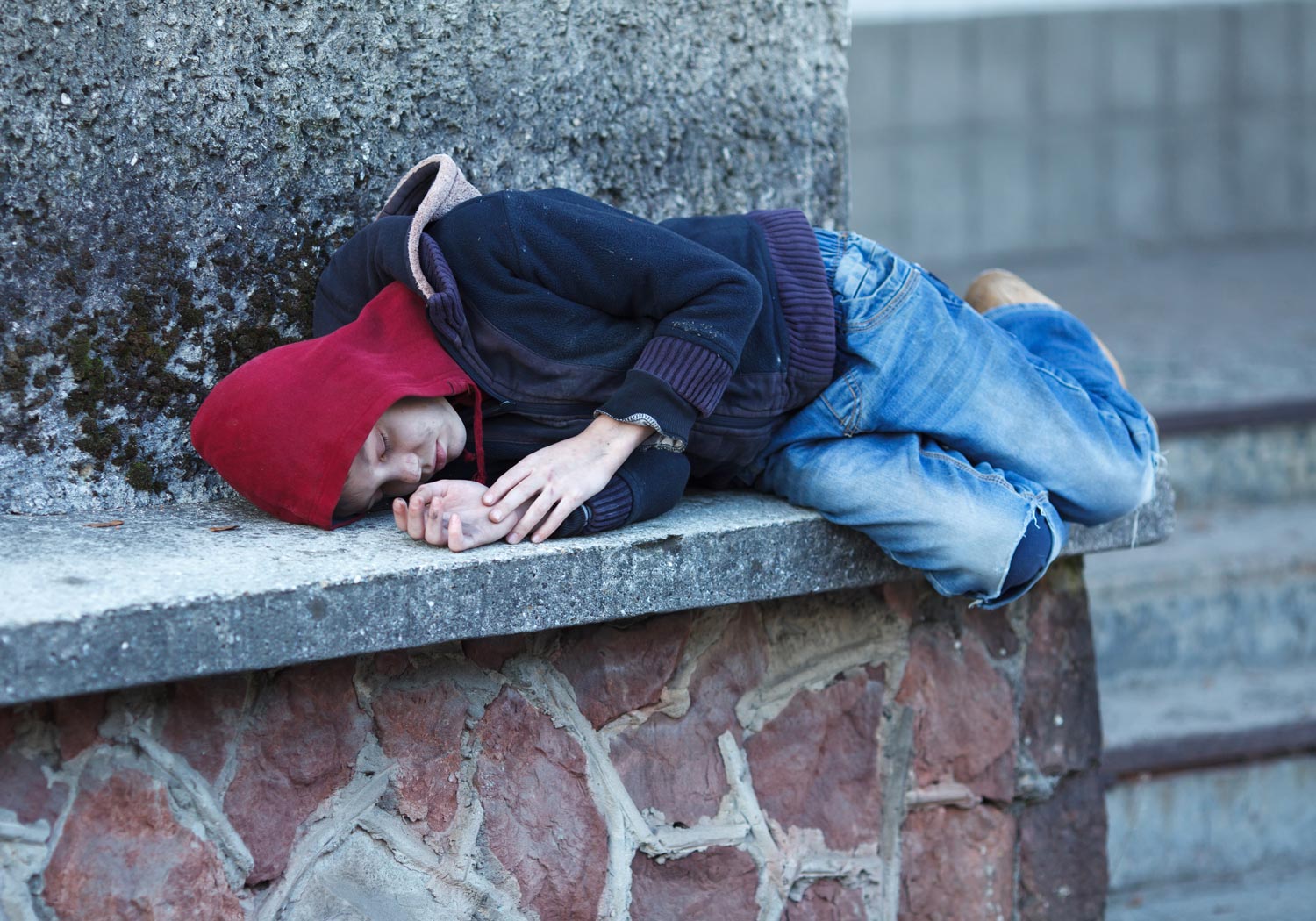Street sleeping. Бездомные дети спят на улице.
